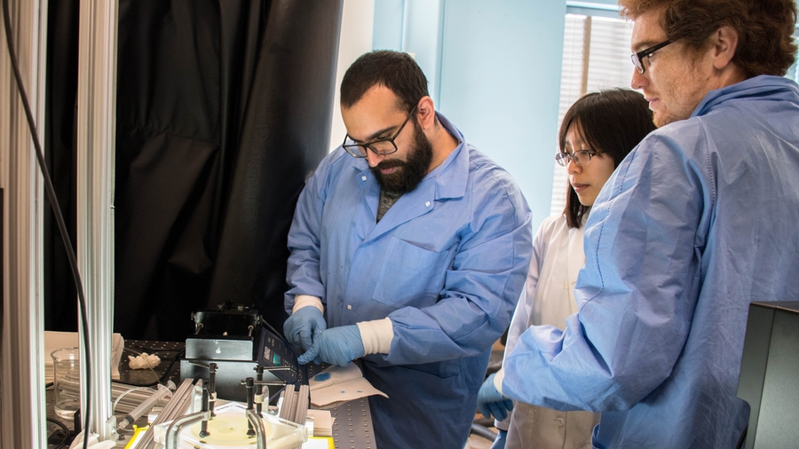 Students Omar Al-Dajani (left) and Rafael Villamor Lora, with teaching assistant Jane Chui (center), set up the fluid injection into a microfluidic device to study fluid-fluid displacement in porous media.