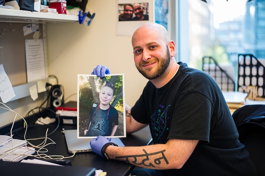 Ryan Kohn, a PhD candidate in the MIT Biology Department’s Jacks Lab, holds a photo of his son, Jayden.