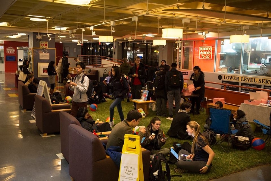 Members of the MIT community enjoy cupcakes and hot chocolate on the indoor lawn.