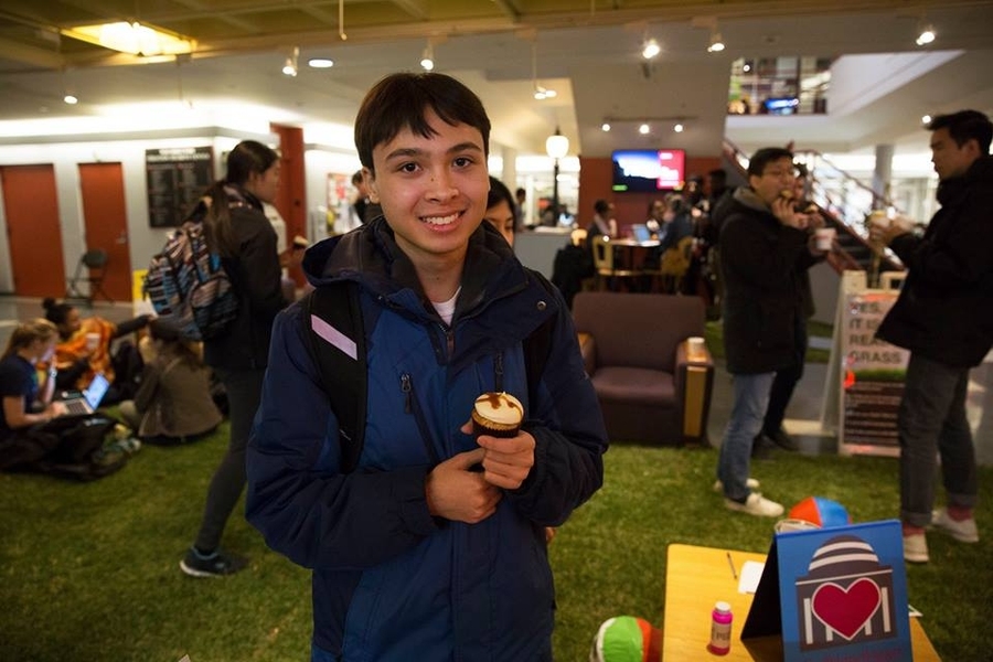 An MIT student enjoys cupcakes on the indoor lawn.