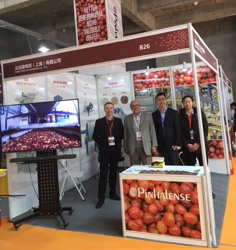 Carlos Brando (second from lelf), a 1998 SPURS fellow and the director of P&A International Marketing, meets with a local team at a coffee processing machinery booth at the first Pu’er International Specialty Coffee Expo in Pu’er City, China.