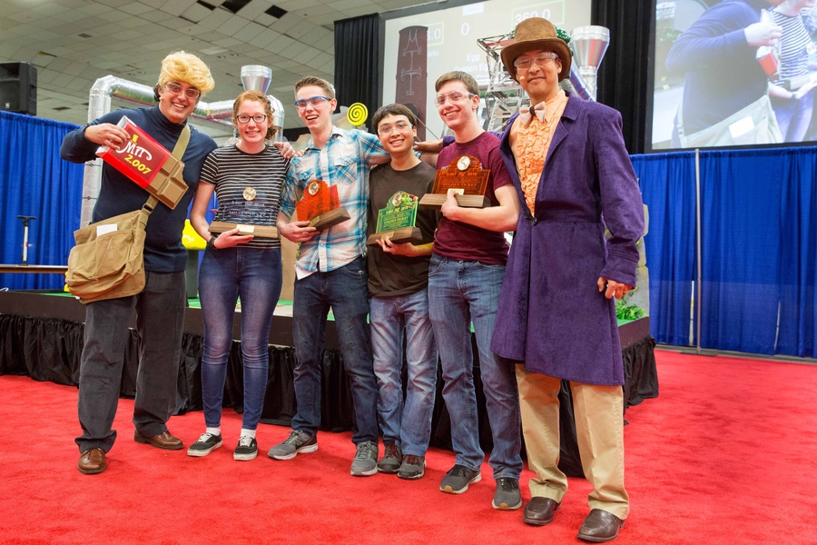 2.007 course instructors Associate Professor Amos Winter (far left) and Associate Professor Sangbae Kim (far right) pose with the top four finalists in the robot competition. From left to right: second place Erika Mynio, first place Mason Massie, fourth place Roberto Bolli, and third place Nathaniel Huffmam. 