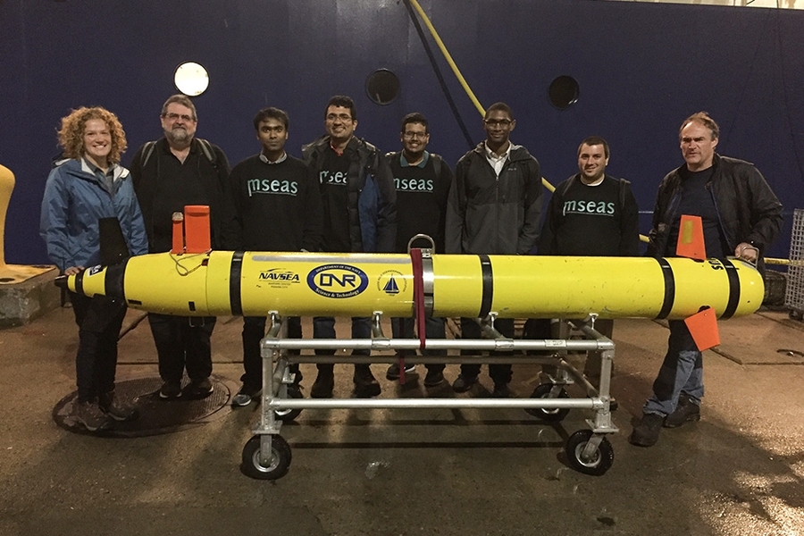Scientists get ready to load an AUV onto a research vessel for a test of navigation and sensing algorithms at sea.