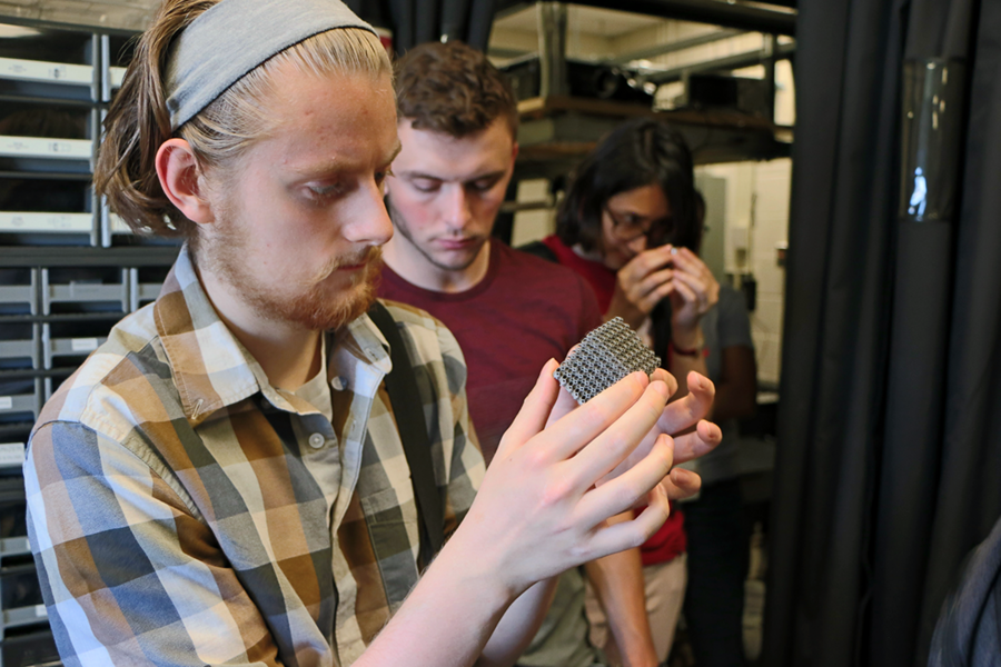 Summer Scholars Ryan Tollefsen (left), Michael Molinski, and Ekaterina (Stella) Tsotsos, examine samples of 3-D-printed metal structures during a tour of Nicholas X. Fang's lab.