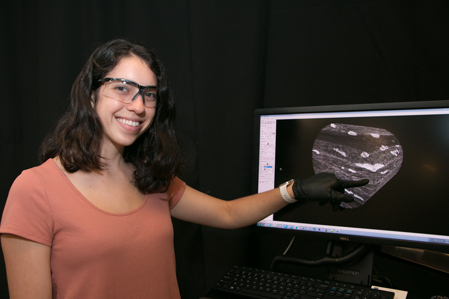 Summer Scholar Abigail Nason points to a 3D rendering of a carbon fiber/epoxy composite laminate with embedded carbon nanotube [CNT] reinforcement that reveals sheets of carbon fibers and polymer as well as micro-scale features of relatively weak inter-sheet regions. Nason conducted research this summer in the lab of Professor Brian L. Wardle, in the Department of Aeronautics and Astronautics. “...