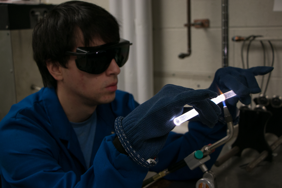 Roxbury Community College student Bruce Quinn uses a hydrogen torch to heat a quartz ampoule, a special tube used for producing powders of compounds such as barium zirconium sulfide, which are desirable for their optical and electrical properties. Quinn interned in the lab of Rafael Jaramillo, an assistant professor of materials science and engineering.