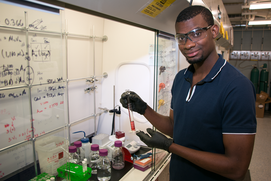 Roxbury Community College student Credoritch Joseph holds a solution of DNA nanoparticles in the lab of assistant professor in materials science and engineering Robert J. Macfarlane. Joseph learned to purify a solution of DNA particles in columns of nanopure water to prepare them for use in self-assembly.
