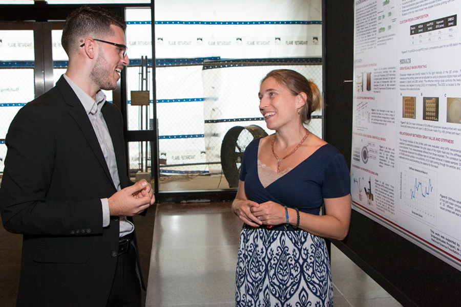 Summer Scholar Fernando Nieves Muñoz (left) discusses his poster with Professor of Materials Science and Engineering Krystyn Van Vliet, in whose lab he interned this summer. Nieves Muñoz used stereolithography 3-D printing to create polymer-based materials to mimic real lesions in the brain caused by multiple sclerosis.
