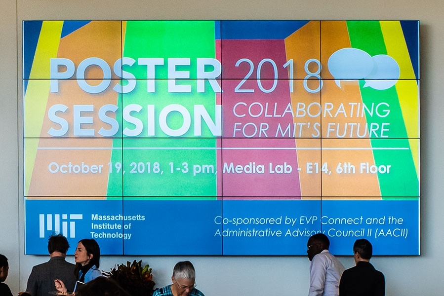 People milling in front of a large display saying "Poster Session 2018: Collaborating for MIT’s Future"