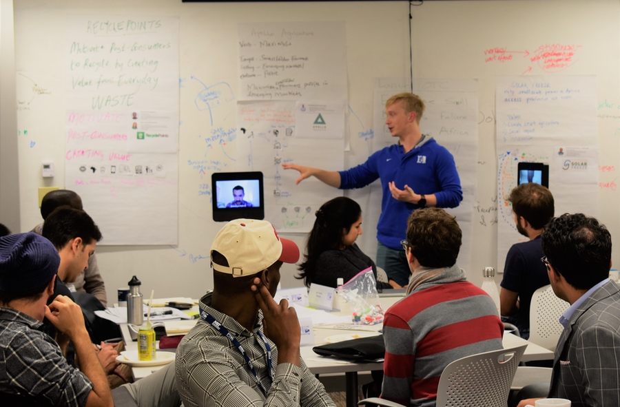 Legatum Fellows Christian Ulstrup (center), Sergio Medina (left robot), and Prosper Nyovanie (right robot) present on startup Apollo Agriculture, based on their conversations with its director of operations Ben Njenga, a forum participant.