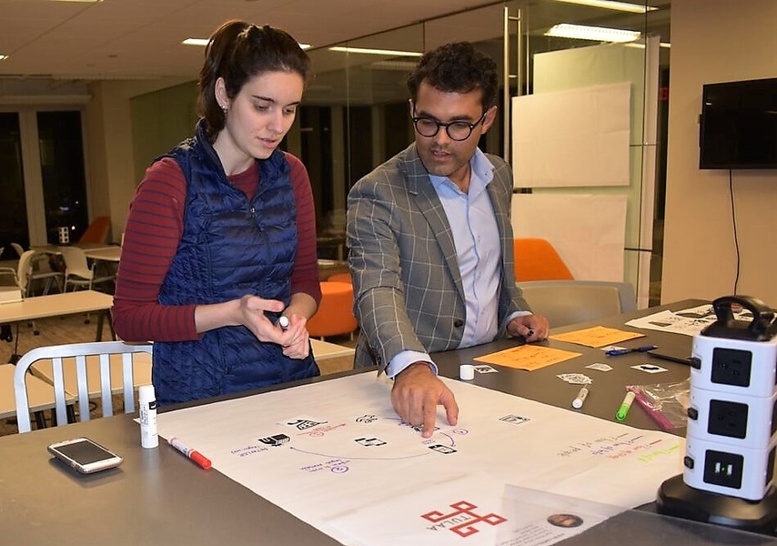 Legatum Fellow Elisa Mansur (left) works with Vishal Ajmera on a visual representation of his venture Tulaa, which Mansur later presented to the Impact Ventures class.