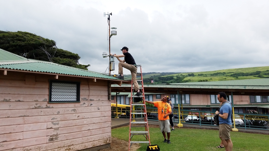 Postdoc Ben Crawford installs a volcanic air pollution sensor at an elementary school on the Big Island of Hawaii. 