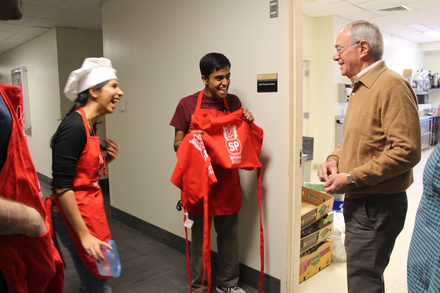 Brunch chairs Geeticka Chauhan and Mayuran Saravanapavanantham present President Reif with a Sydney-Pacific brunch apron to make him an official brunch helper.