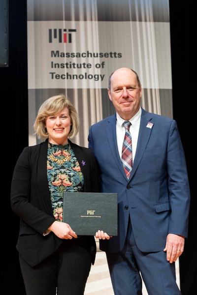 Claire Walsh receives an Outstanding Contributor Award from Provost Martin Schmidt.