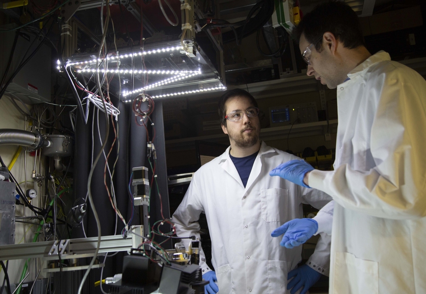 Associate Professor John Hart speaks with graduate student David Griggs in front of his lab’s custom-built selective laser melting system. In the system, a laser is precisely scanned over metal powder, melting the powder to form a 3-D part layer by layer.