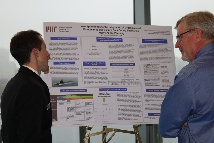 Course 2N graduate student Aaron Sponseller discusses his research on submarine maintenance planning with an attendee at the MIT Ship Design and Technology Symposium.