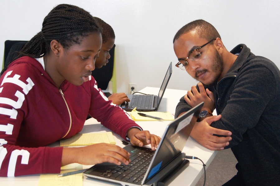 Eyassu Shimelis (right) helps a student work through her code.