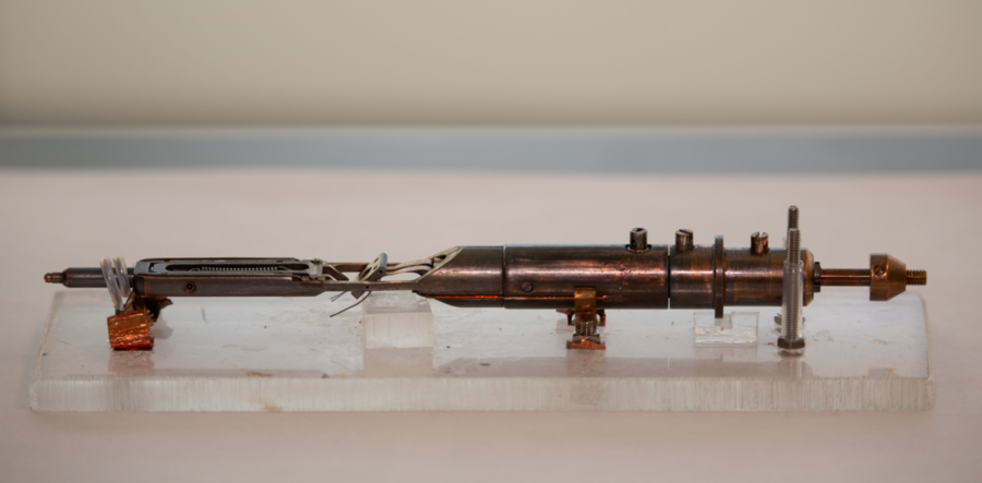 MIT Professor Frances Ross has designed several custom sample holders for examining nanoscale materials in gases and liquid media in the electron microscope. For liquid environments, thin windows of silicon nitride surround the liquid but allow the electron beam to pass through. For gas environments, the sample holder (shown here) must heat and tilt the sample without compromising its cleanliness....