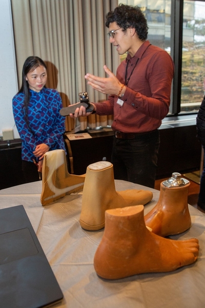 Graduate student Victor Prost (right) discusses his design of an affordable, mass-manufacturable prosthetic foot.