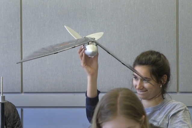 Becca Sholler examines a “bird plane” brought to class by course instructor Professor Daniel Frey to use as a reference for her team's final project.