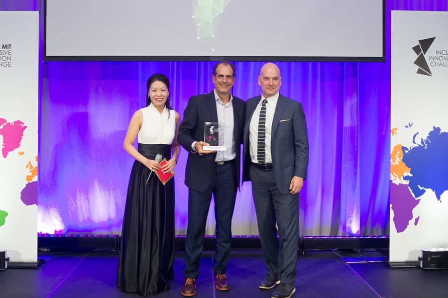 Dan Cohen (middle), the founder of TiendaPago, an online lender giving small stores in Latin America short-term loans, poses with IIC organizers and sponsors after winning the financial inclusion category.