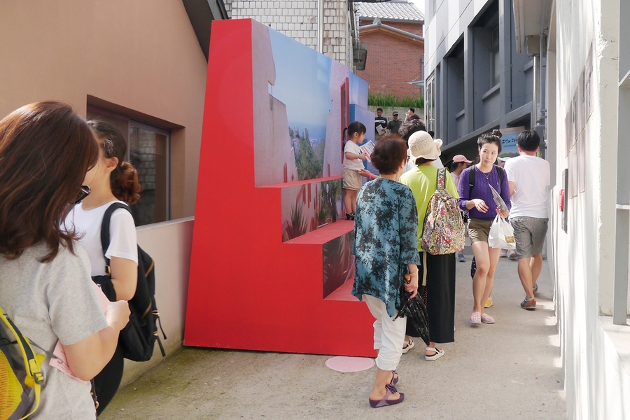 Seoul Architecture and Urbanism Biennale attendees interact with the "Sit(e)lines of a Garden City" installation on the port city of Haifa, Israel.