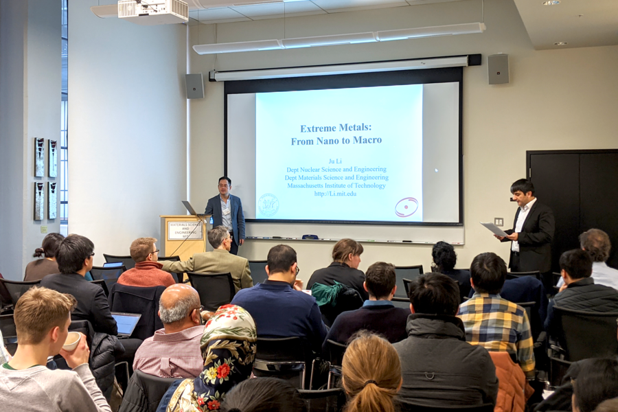 Associate Professor C. Cem Taşan (standing, right) introduces Ju Li (at podium, left), the Battelle Energy Alliance Professor of Nuclear Science and Engineering and professor of materials science and engineering, at the MIT Alloy Design Workshop.