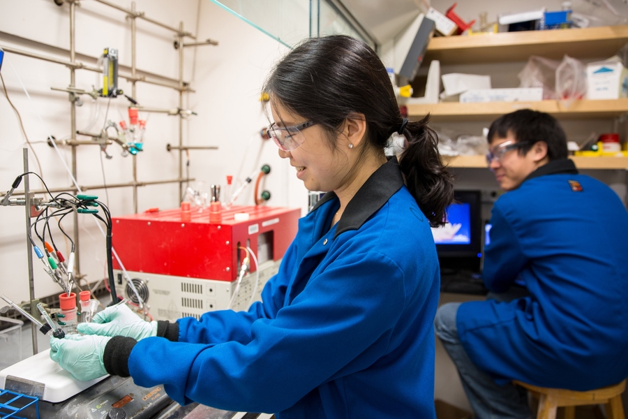 Graduate students Onyu Jung (left) and An Chu set up a carbon dioxide conversion experiment in the Surendranath lab.