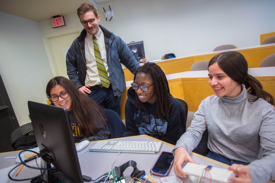 Joe Steinmeyer and SEED Academy students Lea Grohmann (left), Daysia Charles (center), and Yenifer Lemus (right) prepare for their final electronics presentations.