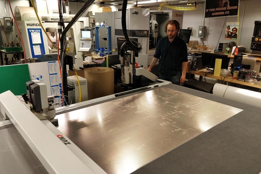 Graduate student Zach Fredin operates the Zund large-format cutter in MIT’s Center for Bit and Atoms. The machine was used to make prototypes of the face shield.