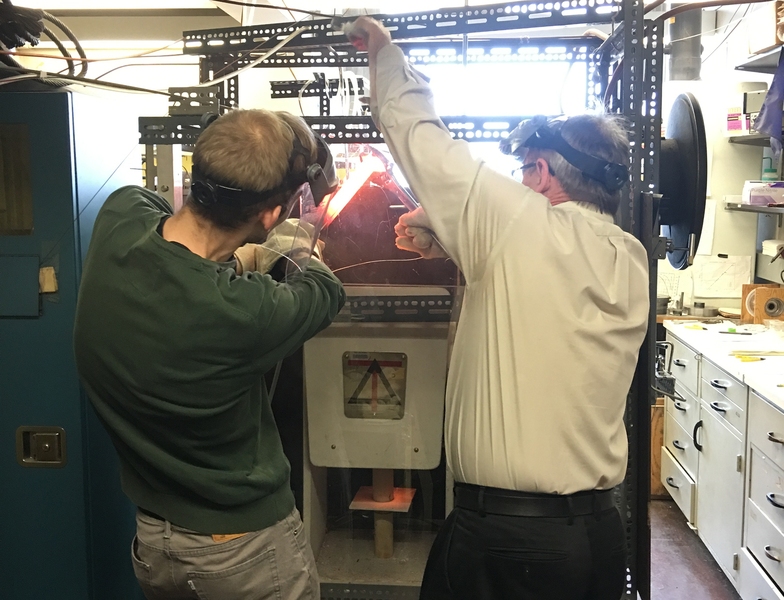 Max Collinet PhD ’19 (left) and Professor Tim Grove work together to extract an experimental sample from a one-of-a-kind rock-melting machine at MIT that reveals clues about planetesimals and the formation of the rocky planets like Earth and Mars. 