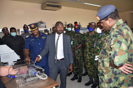 Ameer Mohammed (center, in suit) showcases prototypes early last month to the Nigerian chief of air staff at the Air Force Institute of Technology.