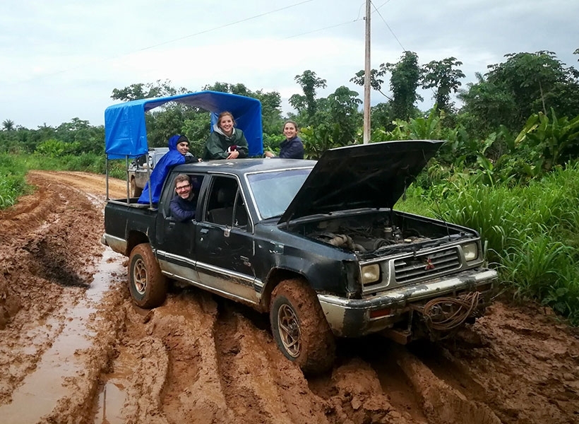 Left to right: Josh McDermott (in vehicle), Alex Durango, Sophie Dolan, and Malinda McPherson experience a travel delay en route to a Tsimane’ village after a heavy rainfall.