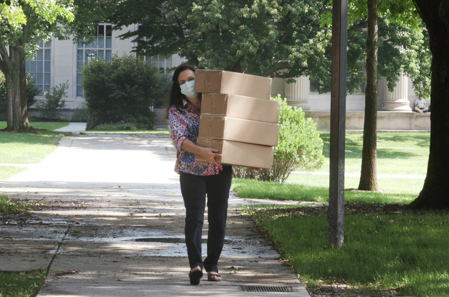 Simona Socrate carries four big boxes across MIT's campus. 