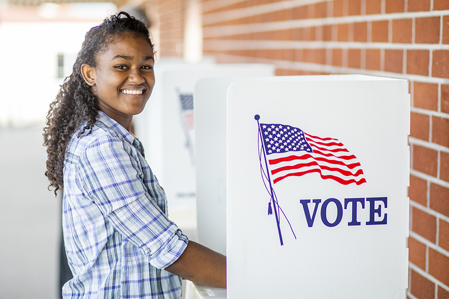Photo of a young woman at a voting booth 