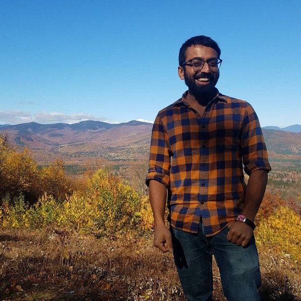 Photo of Ashwin Narayan standing before a landscape