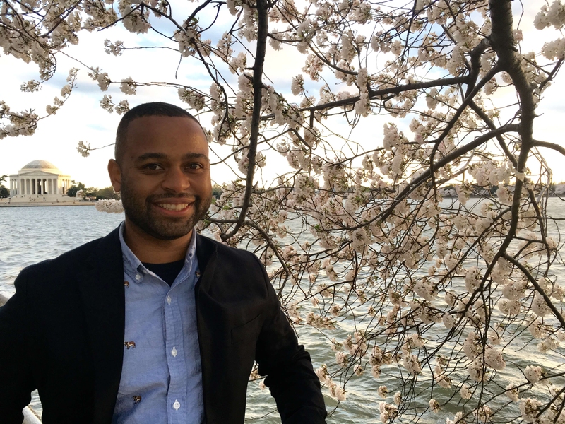 Photo of Thomas Searles in front of a cherry blossom and the Tidal Basin in Washington