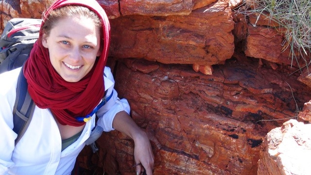 Photo of Tanja Bosak posing in front of an ancient rock