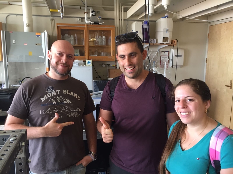 Photo of three people posing and smiling in a lab