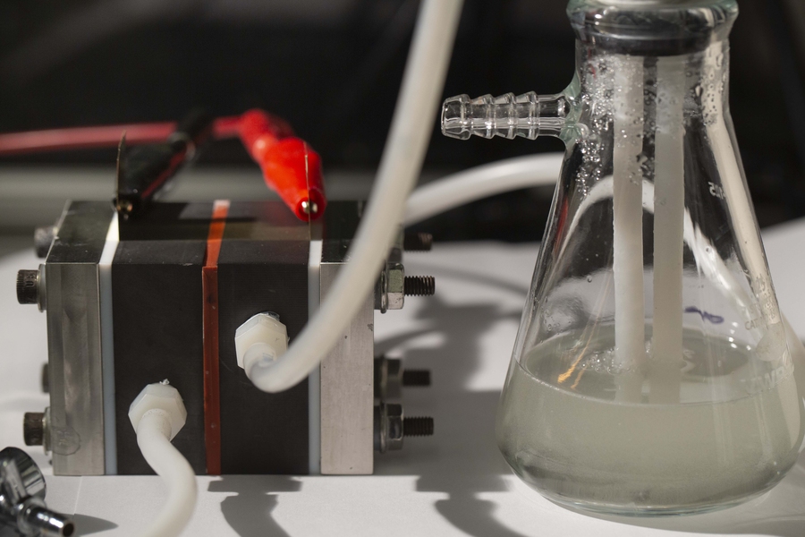 Photo showing a small box with tubes coming out of it, and a flask with white liquid inside