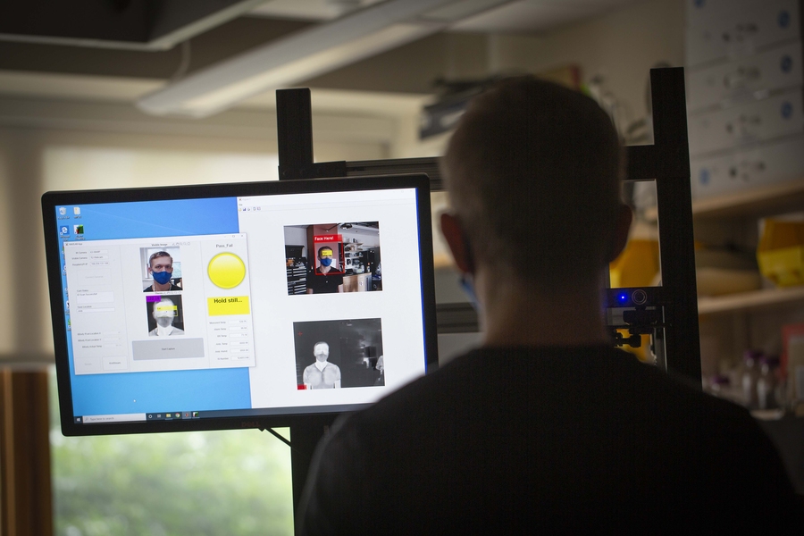 Photo of a person standing in front of the camera to have their temperature scanned