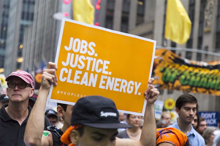 Photo from the March for Science showing a sign reading “Jobs, Justice, Clean Energy"