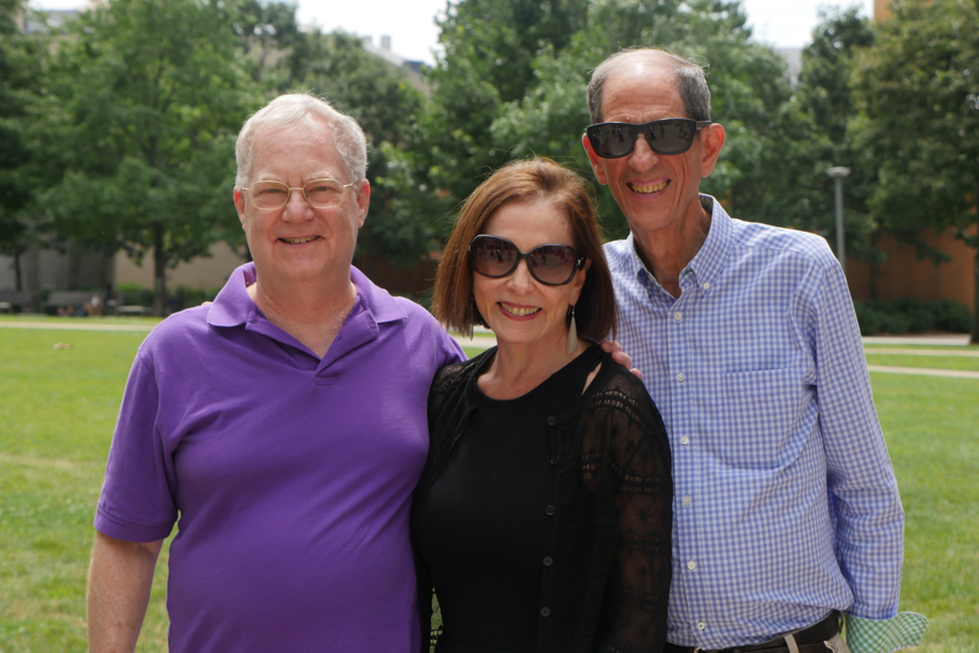 Photo of three people smiling together on Hockfield Court at MIT