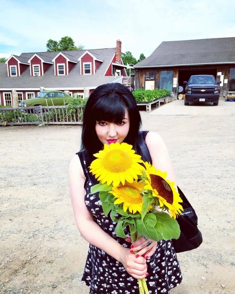 Photo of Heather Theberge holding sunflowers