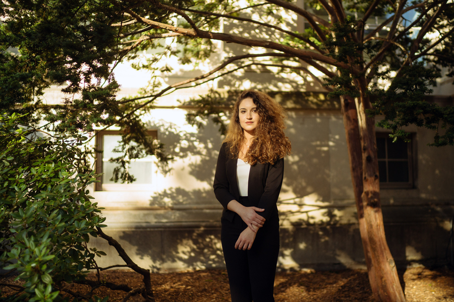 Photo of Maya Nasr standing in the shade of a tree on a sunny day