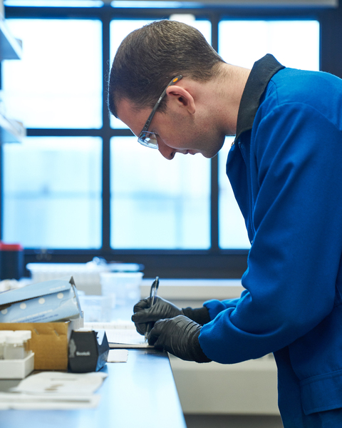 Photo of Ty Christoff-Tempesta in the lab, writing something down
