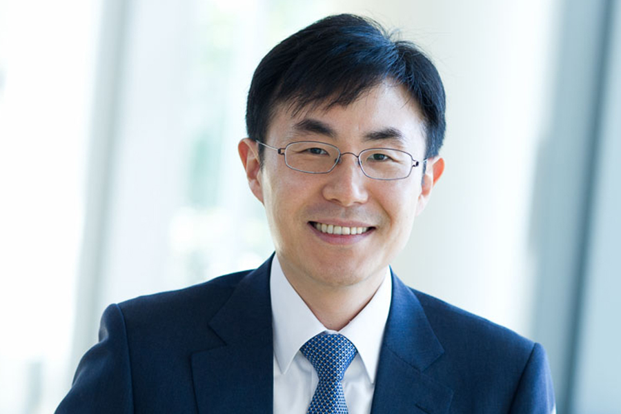 Headshot of In Song Kim, wearing a suit and tie