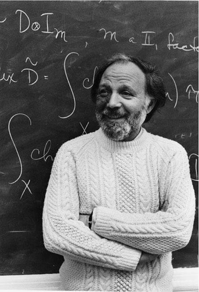 Black-and-white photo of Isadore Singer in front of a blackboard with mathematical equations