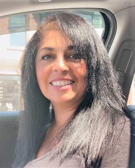 Photo of Lidia Vasconcelos sitting in a car and smiling