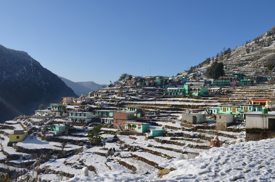 Photo of the terraced hill town of Ransi, India covered in snow